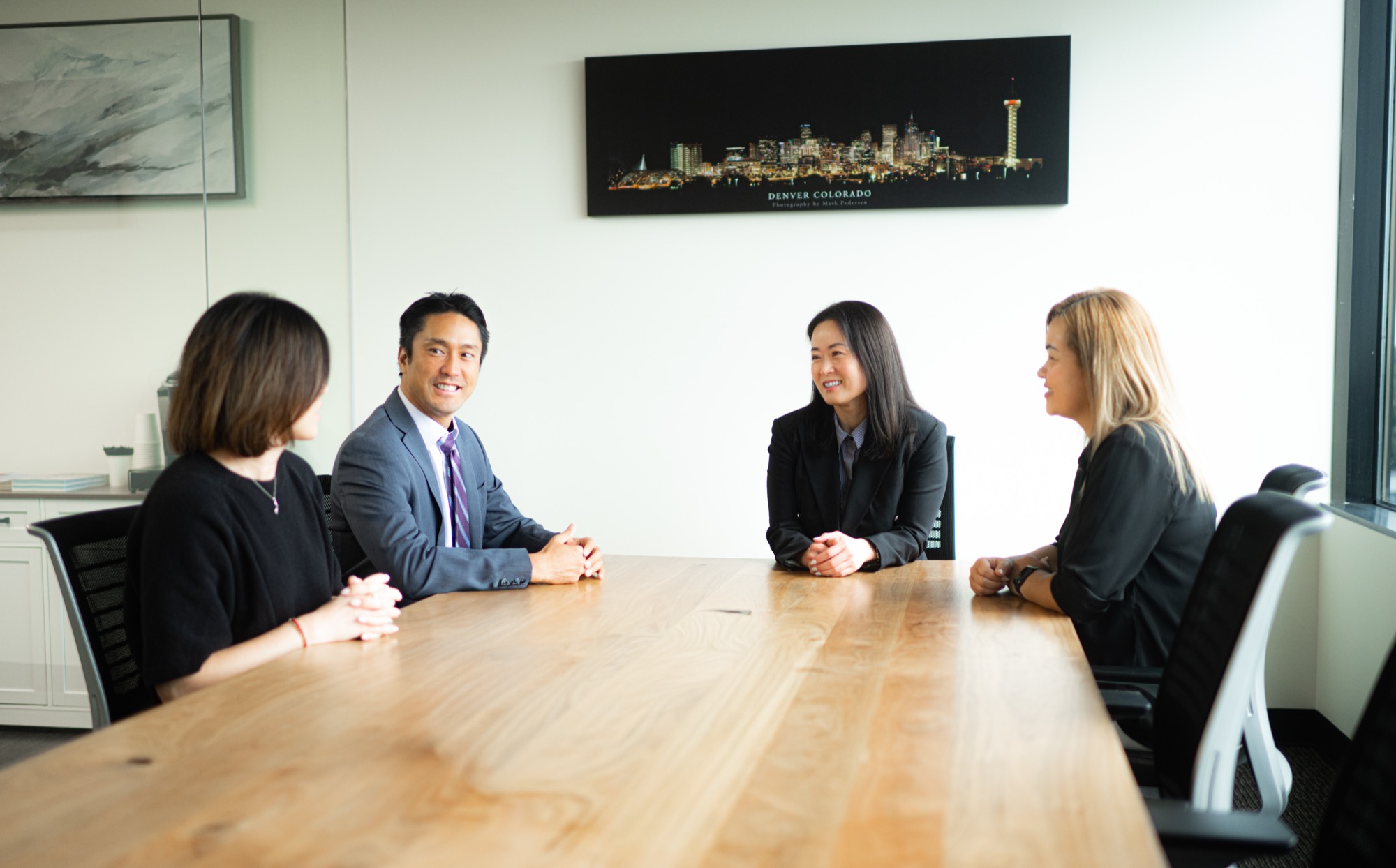 The Son & Suh Law team meeting in the firm's Aurora conference room